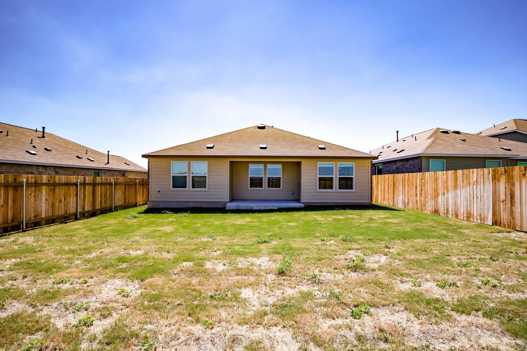 614 Milliner Loop Hutto, TX 78634 - Photo 4 of 25 A spacious, enclosed backyard offers ample room for outdoor activities.