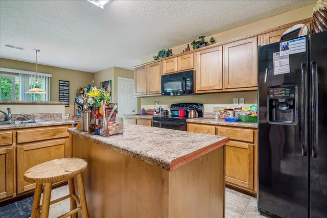 a kitchen with a refrigerator a stove and a sink