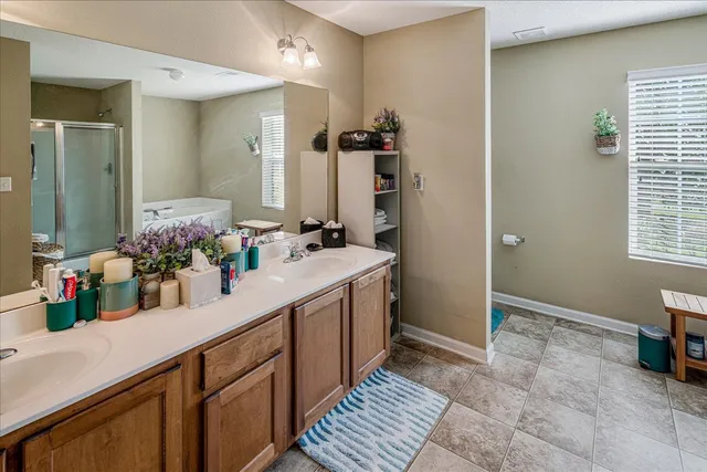 a bathroom with a double vanity sink a mirror and a shower