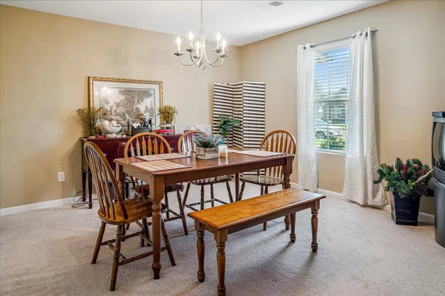 a dining room with furniture potted plants and wooden floor