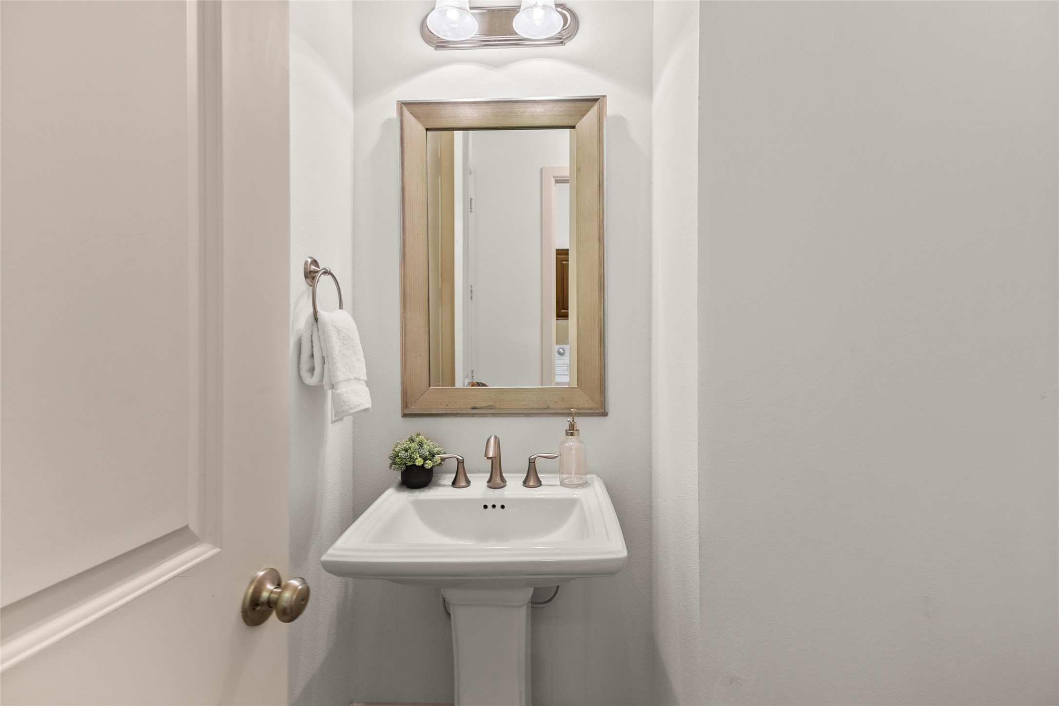 3302 Rochdale Street Houston, TX 77025 - Photo 17 of 50 Conveniently located on the first floor across from the dining room, this powder bath offers a classic pedestal sink and framed mirror for a touch of timeless style. Soft lighting and a clean, crisp palette make it a bright and welcoming space for guests. It's a thoughtfully placed half bath that adds everyday convenience to the main living areas.