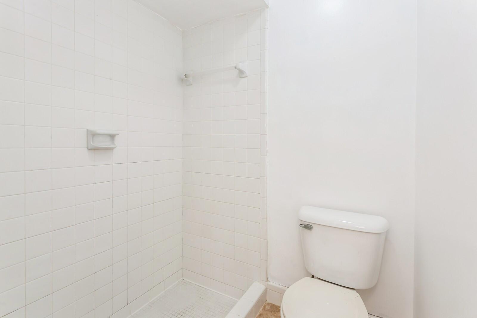 1217 Surf Road, Unit 2 Singer Island, FL 33404 - Photo 11 of 18 a white toilet sitting next to a shower