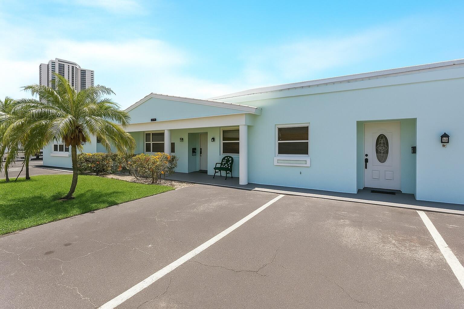 1217 Surf Road, Unit 2 Singer Island, FL 33404 - Photo 17 of 18 a view of a house with a yard and palm trees