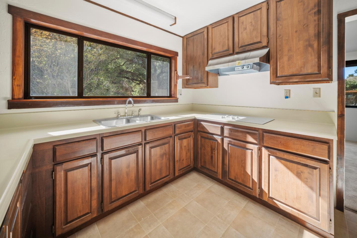 59 Boronda Road Carmel Valley, CA 93924 - Photo 17 of 43 a kitchen with stainless steel appliances granite countertop white cabinets a sink and a large window