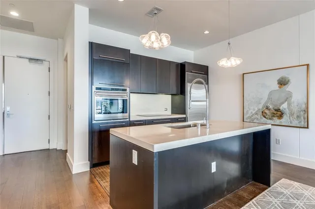 a kitchen with kitchen island a counter space a sink and stainless steel appliances