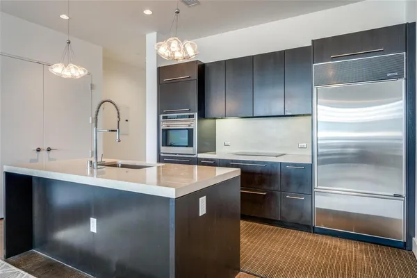 a kitchen with kitchen island granite countertop a sink stove and refrigerator