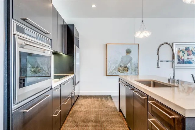 a kitchen with stainless steel appliances granite countertop a sink and a refrigerator