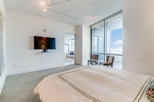 a bedroom with a bed and a flat tv screen on wall