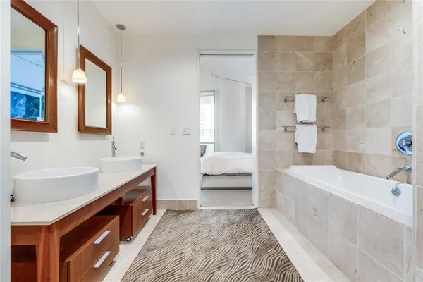 a spacious bathroom with a tub sink and mirror