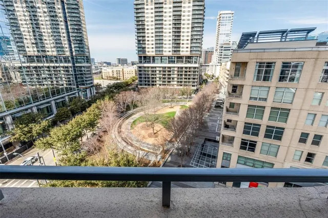 a view of a balcony with a couple of cars parked in front of a building