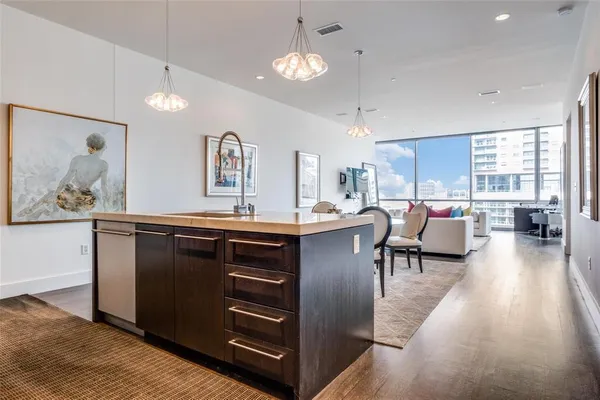 a living room with stainless steel appliances kitchen island granite countertop a rug a stove and a wooden floors