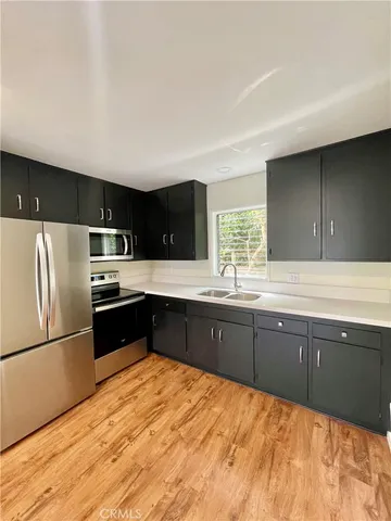 a kitchen with granite countertop a refrigerator and a sink