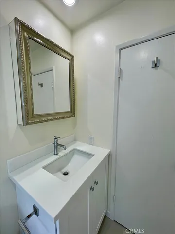 a bathroom with a sink vanity and mirror