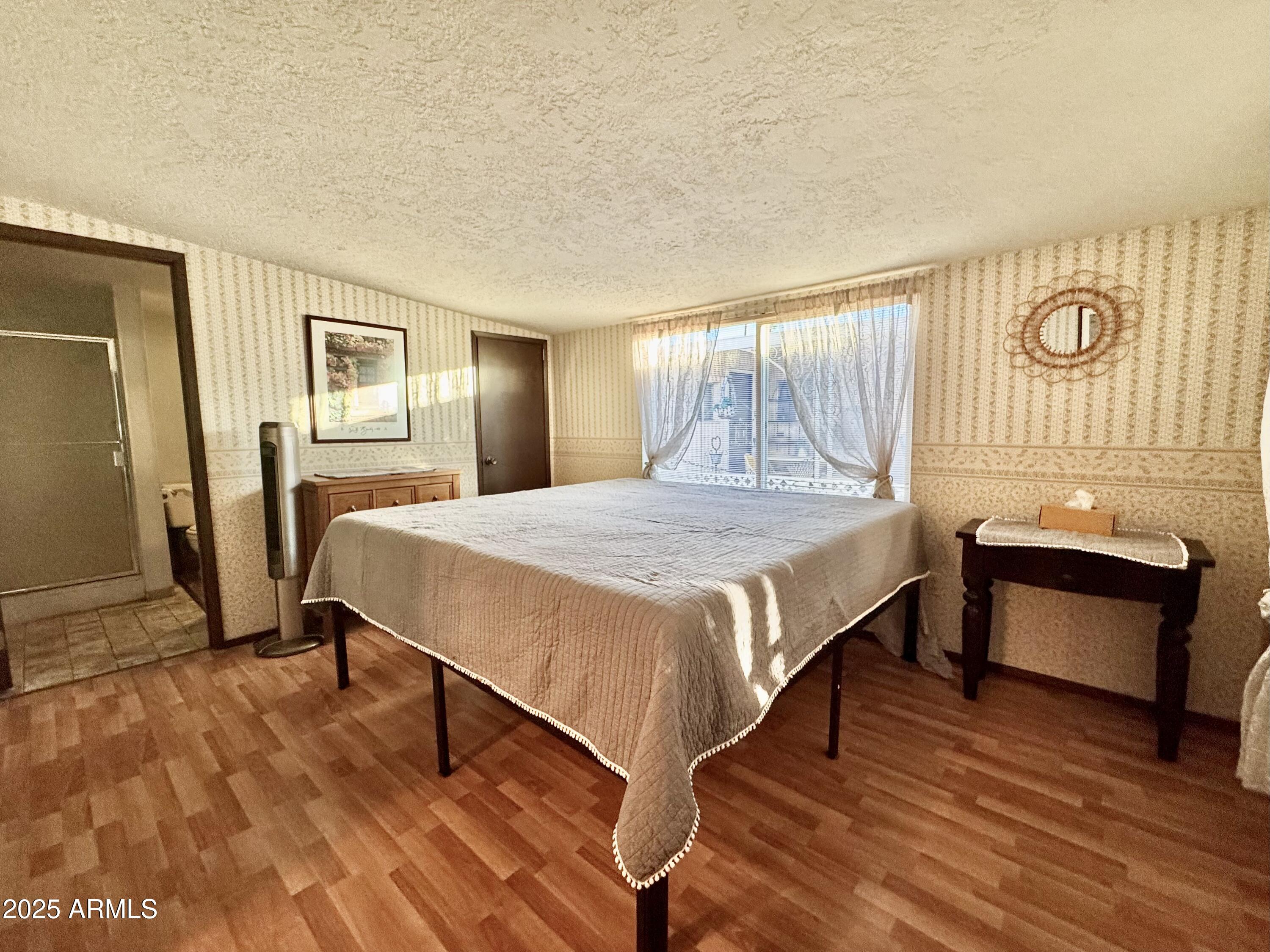 303 South Recker Road, Unit 215 Mesa, AZ 85206 - Photo 12 of 19 a bedroom with a bed chair and a dresser