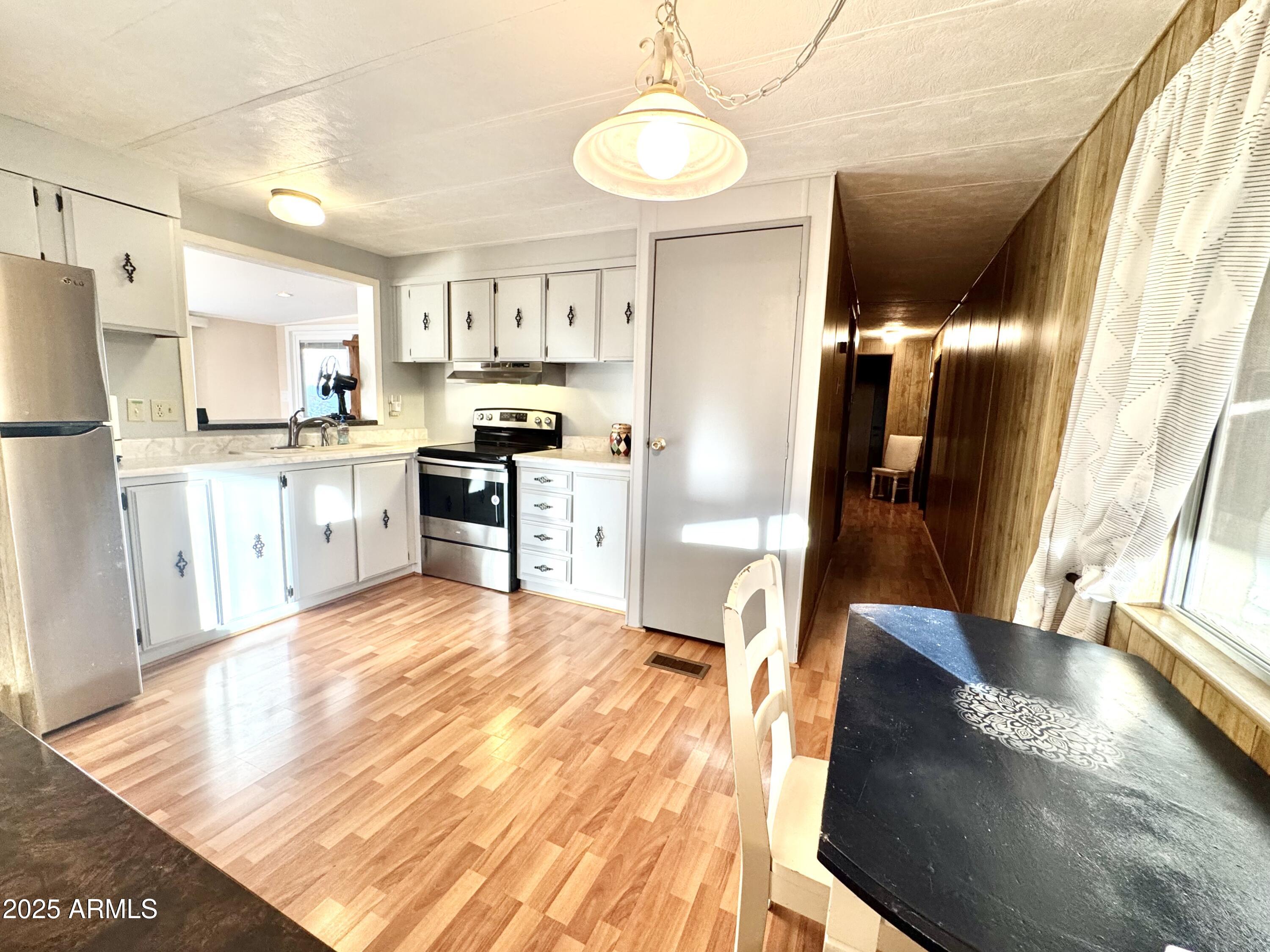 303 South Recker Road, Unit 215 Mesa, AZ 85206 - Photo 7 of 19 a large kitchen with kitchen island a large window appliances and furniture
