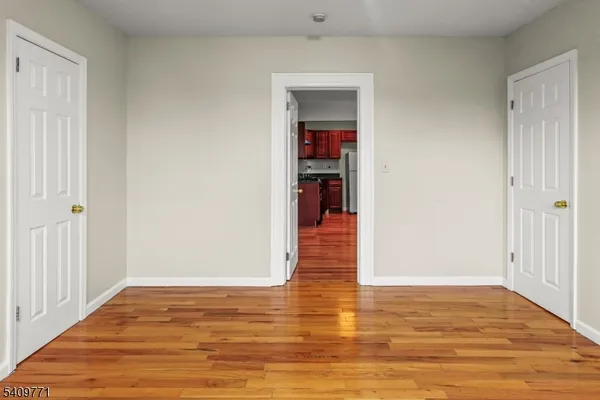 a view of an empty room with wooden floor
