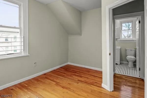 a view of a room with wooden floor and a bathroom