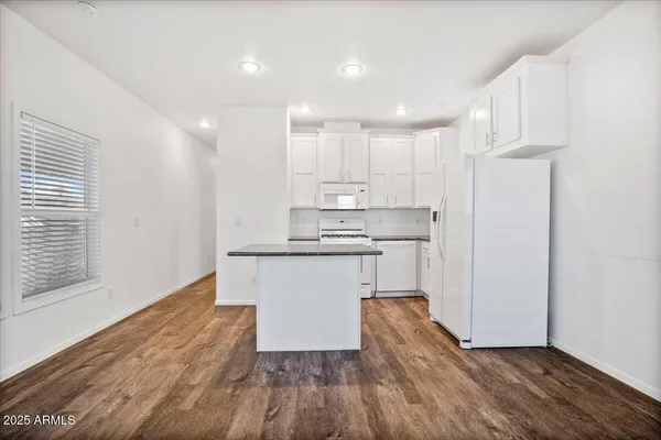 a kitchen with a refrigerator and white cabinets