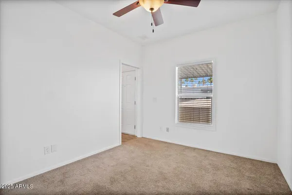 an empty room with a chandelier fan