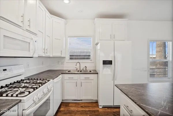 a kitchen with stainless steel appliances granite countertop a sink stove and refrigerator