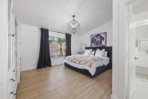 a bedroom with a large bed and a chandelier
