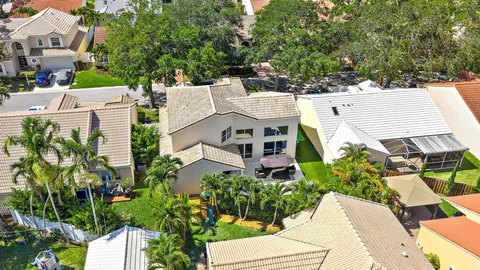 an aerial view of residential house with outdoor space and trees all around