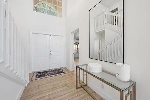 a view of a hallway with wooden floor and staircase
