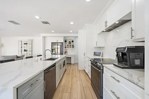 a large kitchen with a large counter top appliances and cabinets