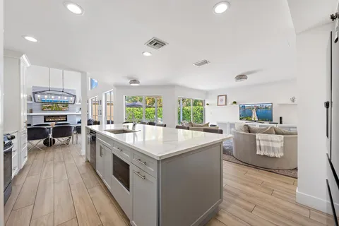 a large kitchen with kitchen island a large counter space a sink appliances and cabinets