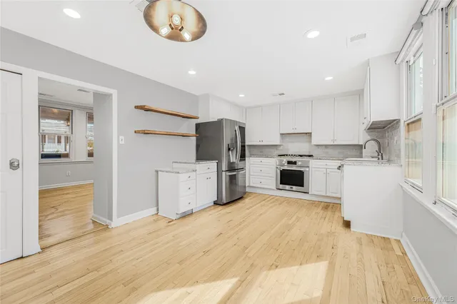 a kitchen with white cabinets and stainless steel appliances