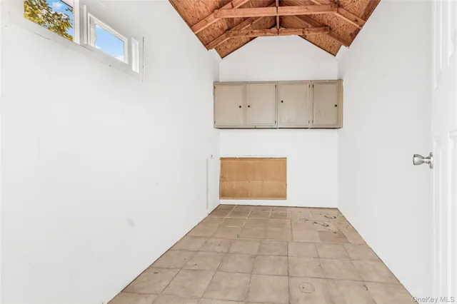 an empty room with white walls and cabinet