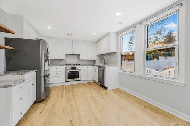 a kitchen with stainless steel appliances a refrigerator sink and cabinets