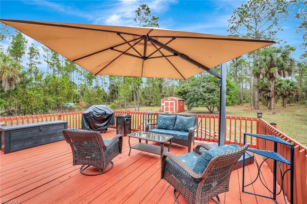 660 20th Street Southeast Naples, FL 34117 - Photo 14 of 17 Deck featuring outdoor lounge area, a storage shed, area for grilling, and a yard