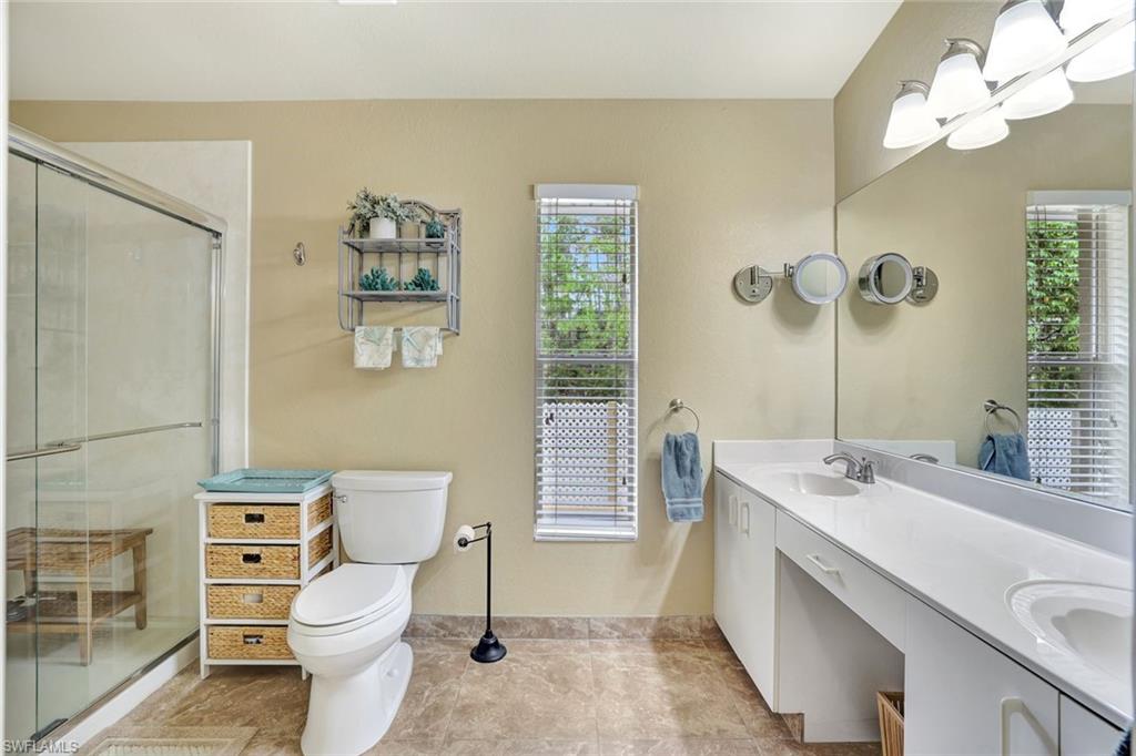 660 20th Street Southeast Naples, FL 34117 - Photo 9 of 17 Bathroom featuring double vanity, a stall shower, and healthy amount of natural light
