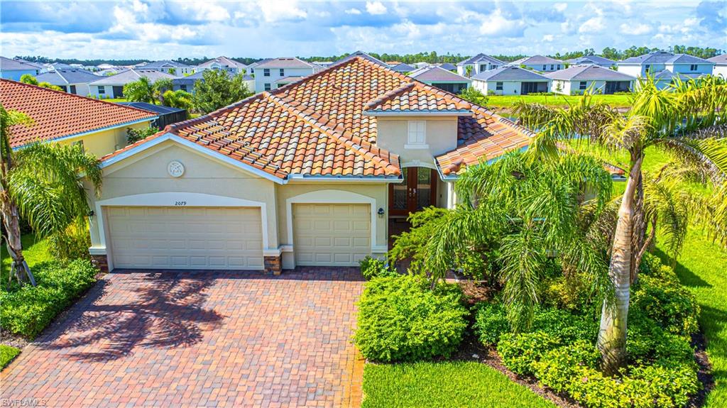 2079 Vermont Lane Naples, FL 34120 - Photo 3 of 13 a front view of a house with a yard and garage