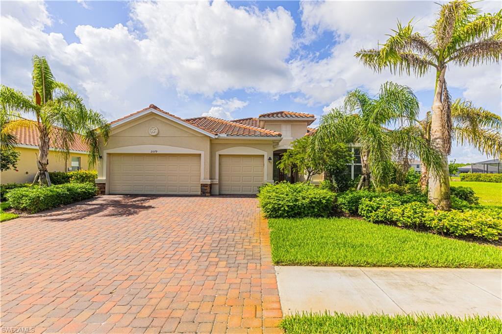2079 Vermont Lane Naples, FL 34120 - Photo 4 of 13 a front view of a house with a garden