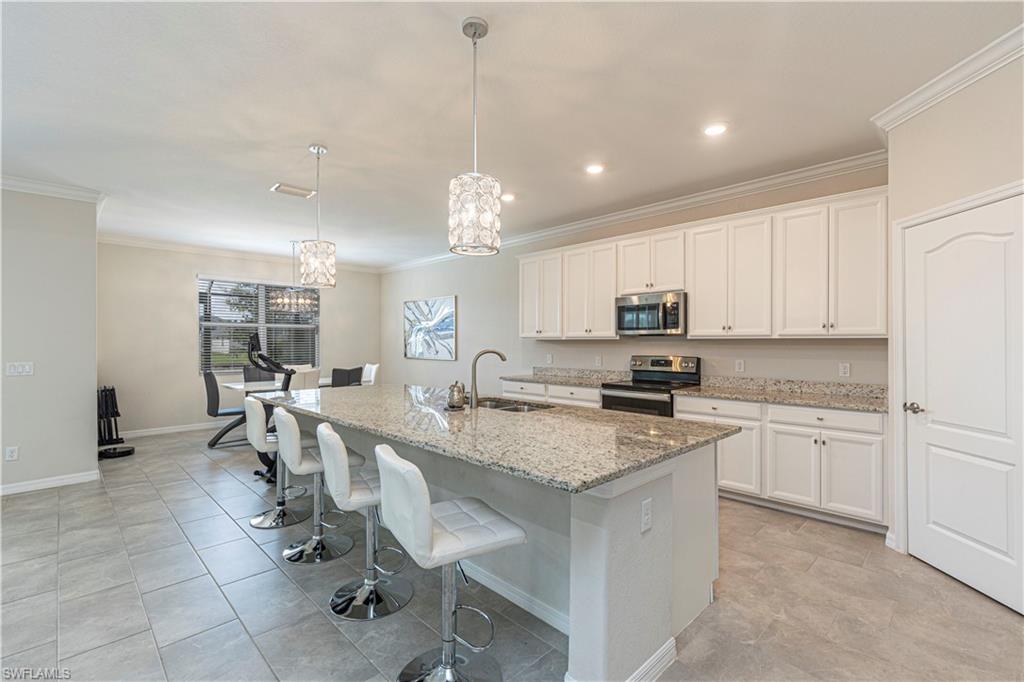 2079 Vermont Lane Naples, FL 34120 - Photo 8 of 13 a kitchen with sink cabinets and dining table chair