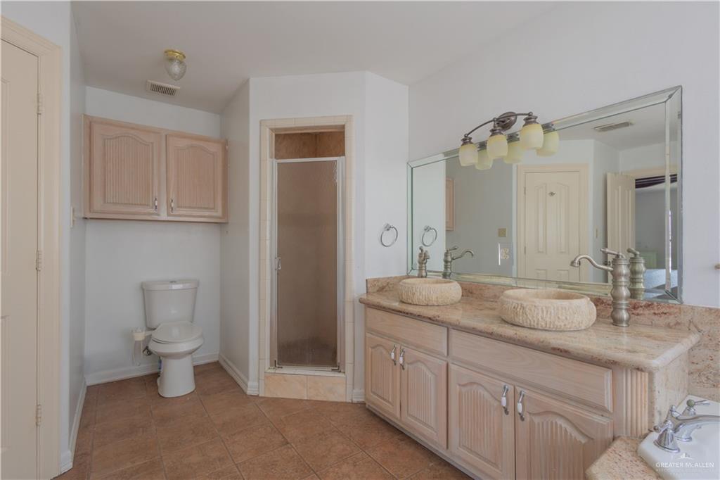 3909 Tulipan Street Mission, TX 78573 - Photo 13 of 16 a bathroom with a toilet sink and mirror