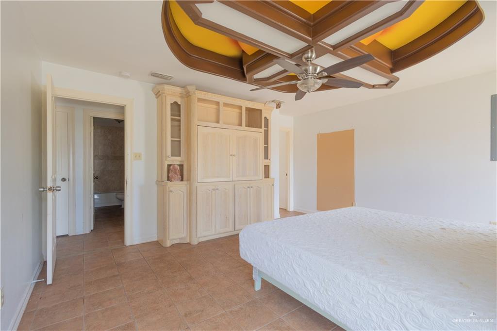 3909 Tulipan Street Mission, TX 78573 - Photo 8 of 16 a bedroom with a bed and a chandelier