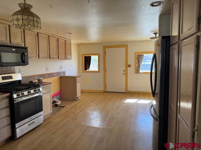 502 South Ash Street Cortez, CO 81321 - Photo 8 of 14 a kitchen with a refrigerator and a stove top oven