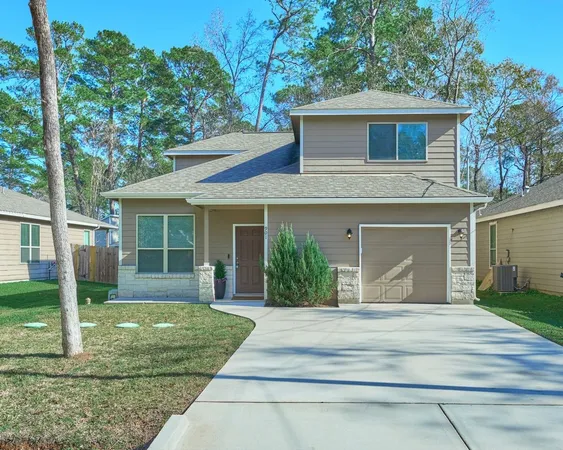 a front view of a house with a yard and trees