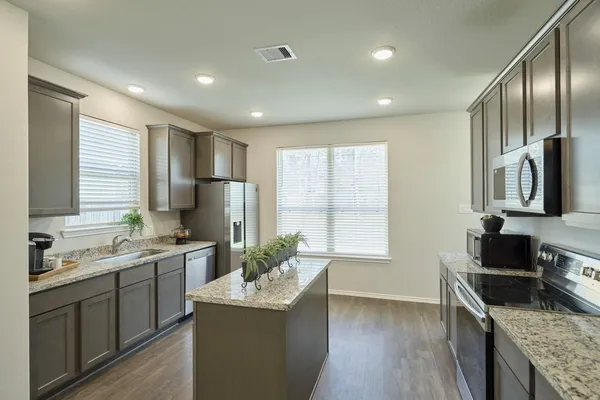 a kitchen with stainless steel appliances granite countertop a sink stove and refrigerator