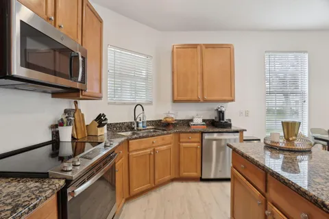 a kitchen with granite countertop cabinets a dining table and chairs
