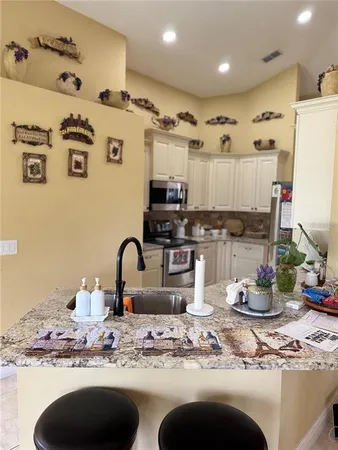 a kitchen with stainless steel appliances granite countertop a stove a sink and a microwave
