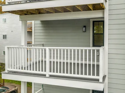 a view of a balcony with wooden floor and fence