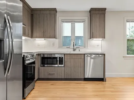 a kitchen with stainless steel appliances granite countertop a refrigerator a sink a stove and oven