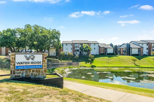 a front view of multi story residential apartment building with yard and outdoor seating