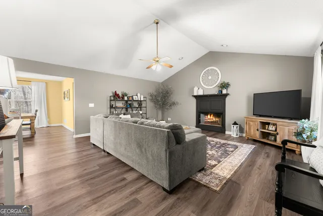 a living room with furniture a flat screen tv and a fireplace