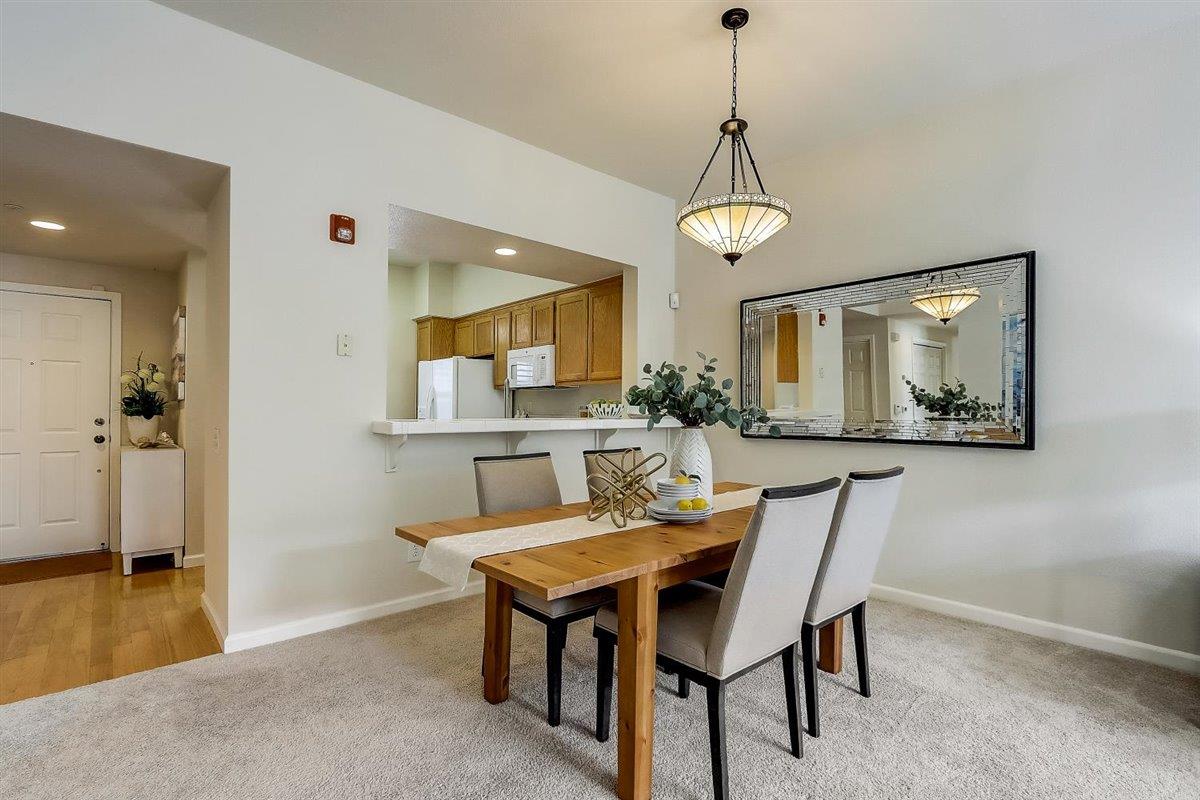 633 Swallowtail Court Brisbane, CA 94005 - Photo 12 of 42 a dining room with wooden floor a chandelier a wooden table and chairs