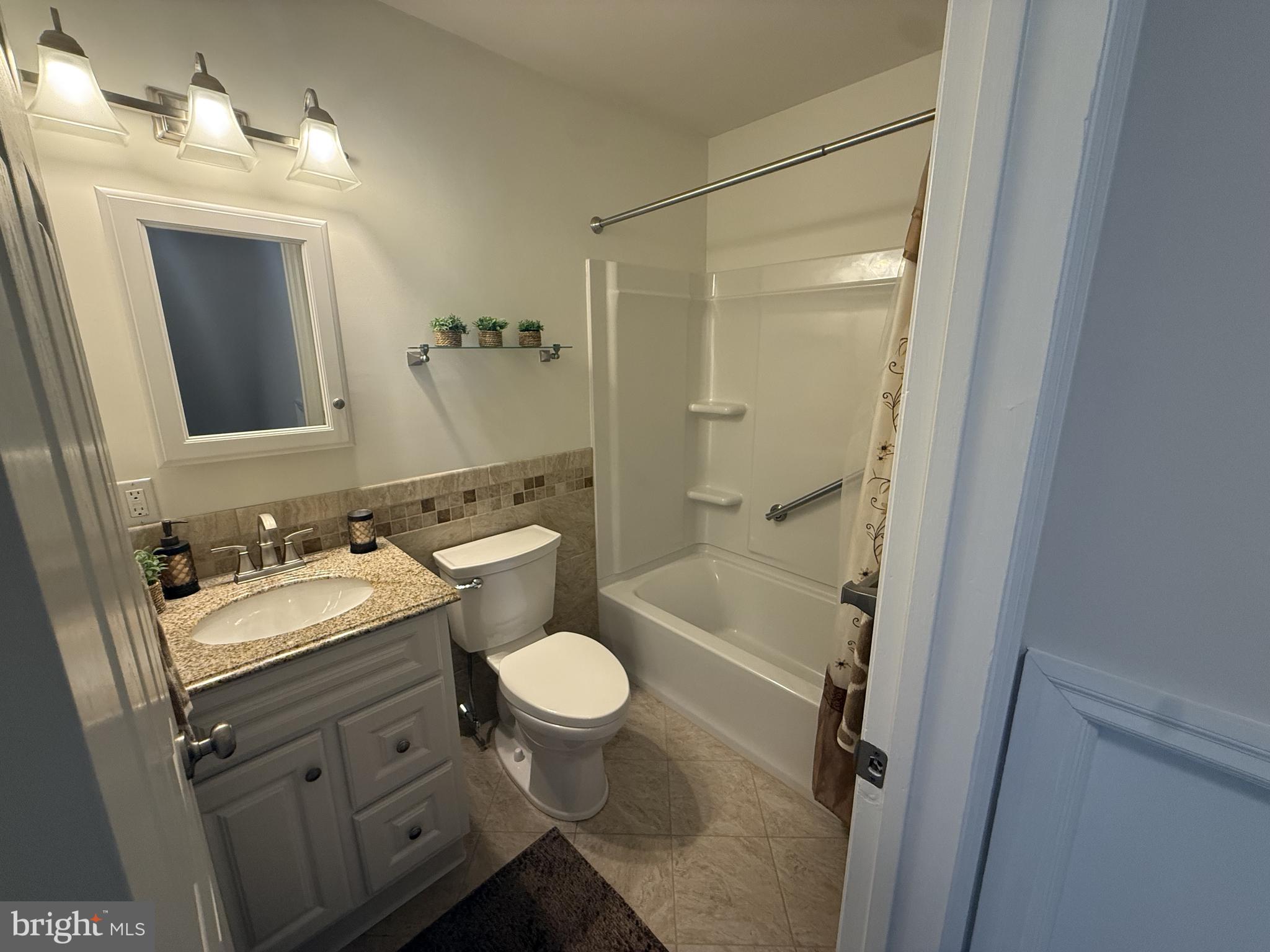 513 Pershing Road Hockessin, DE 19707 - Photo 11 of 17 a bathroom with a sink toilet a mirror and shower